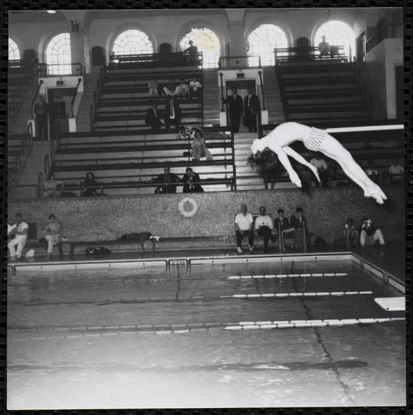 A boy performs a dive at a Boys’ Club swimming championship